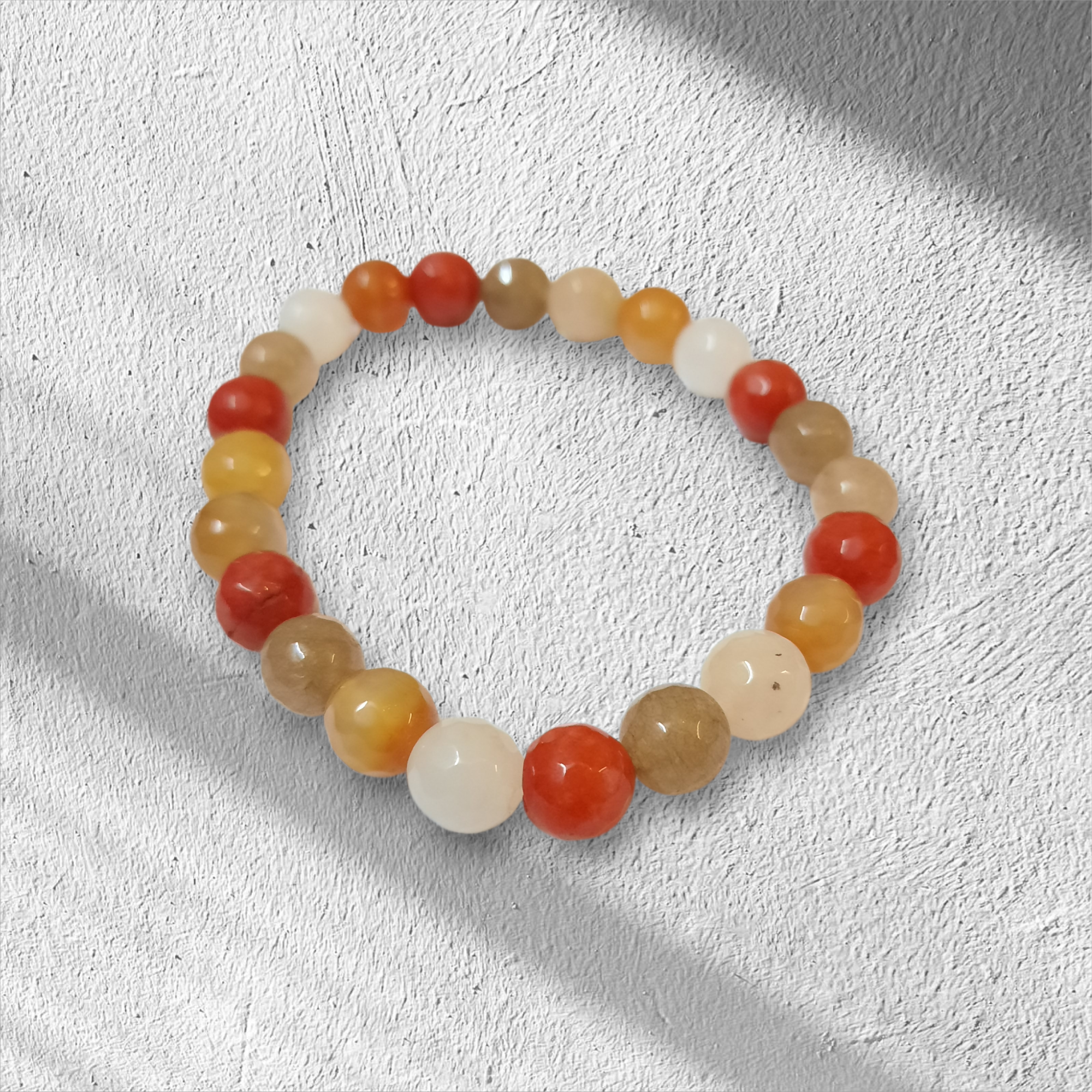 أسوارة أحجار طبيعية ملونة بخيط مطاطي فوق خلفية بيضاء محببة