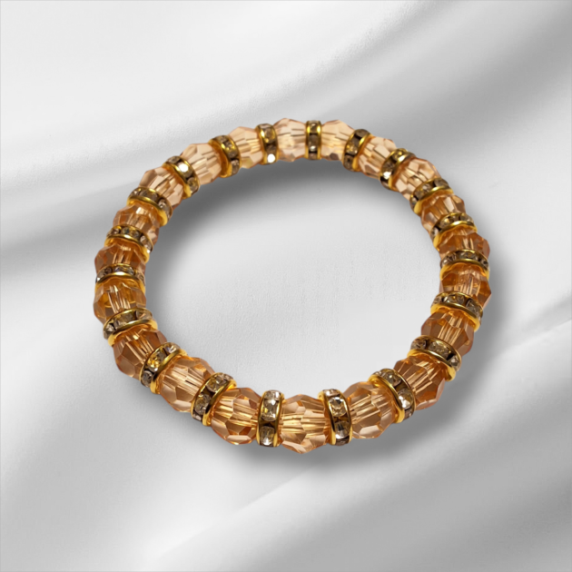 أسوارة كريستال مضلع عسلي بفواصل ذهبية مرصعة فوق خلفية حريرية بيضاء