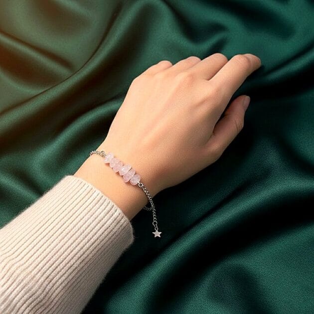 أسوارة فضية بقلادات أحجار كوارتز وردي على معصم امرأة