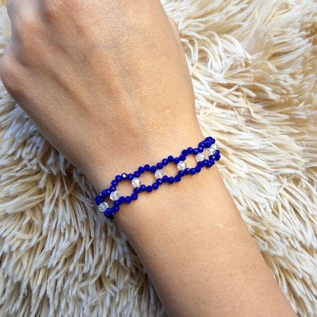 أسوارة خرز كريستال أزرق ملكي بتصميم حلقات مفرغة على معصم امرأة