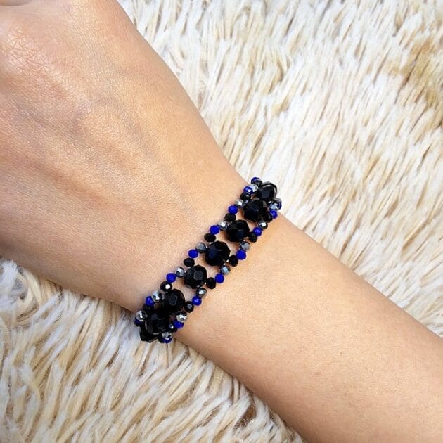 أسوارة خرز أسود ونيلي بتصميم حلقات مفرغة على معصم امرأة