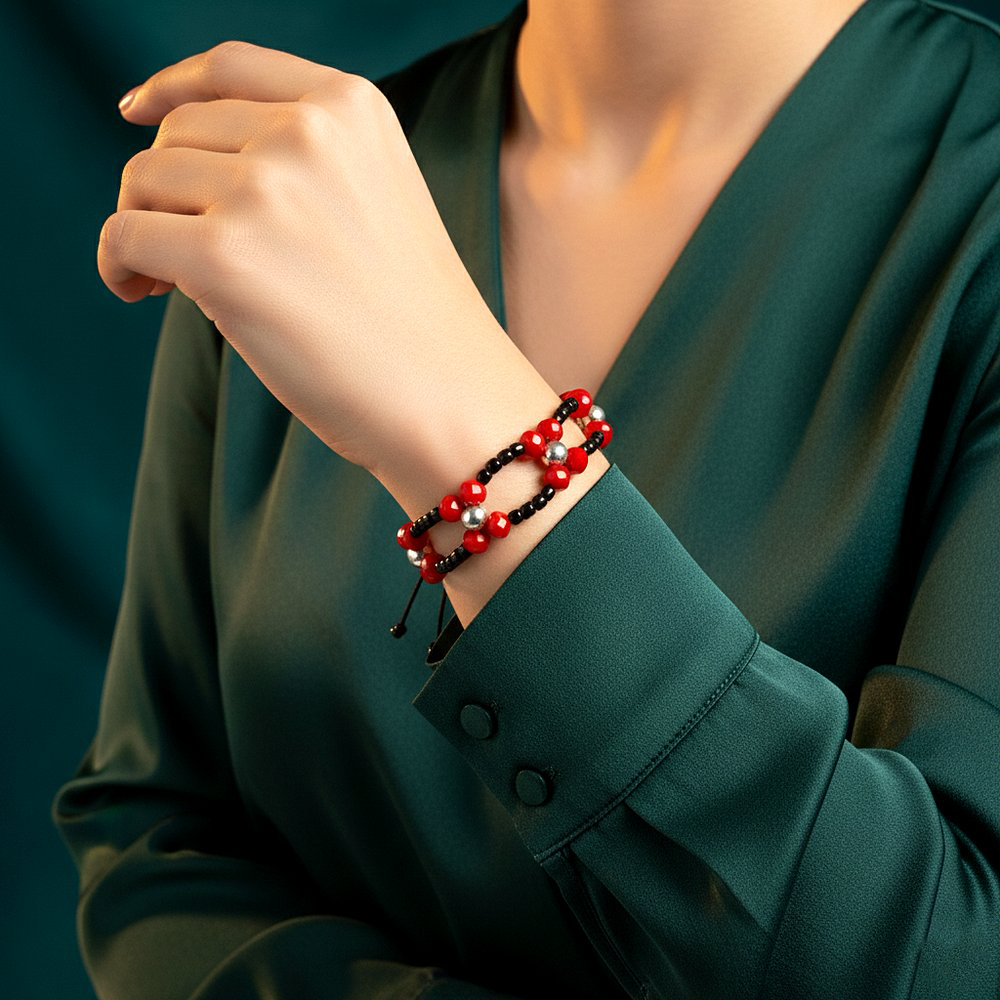 أسوارة خرز أحمر وأسود بطبقتين مع تفاصيل فضية على معصم أنثوي