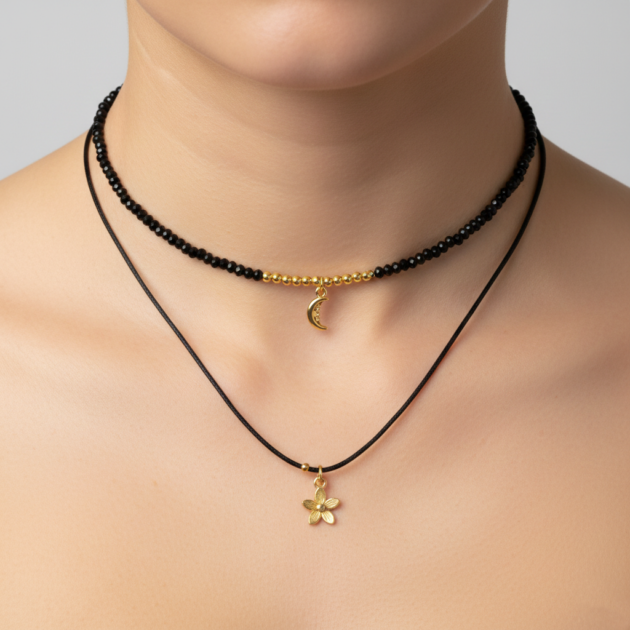 طوق دبل من خرز أسود وخيط أسود مع تعليقة قمر وزهرة بتصميم عصري على الرقبة.
