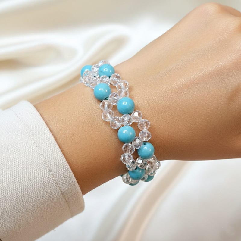 أسوارة عريضة من الكريستال الشفاف وأحجار الفيروز على معصم امرأة