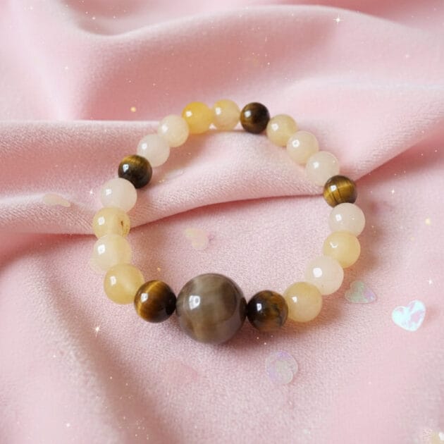 أسوارة خرز من أحجار القمر وعين النمر الطبيعية على خلفية وردية