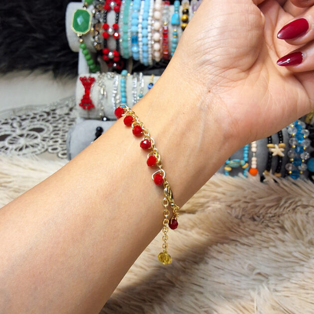 أسوارة كريستال أحمر بسلسلة ذهبية على المعصم