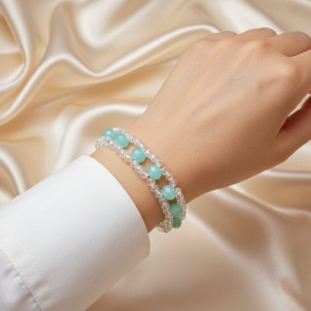 أسوارة عريضة من الكريستال الشفاف والخرز الأخضر المائي على معصم امرأة