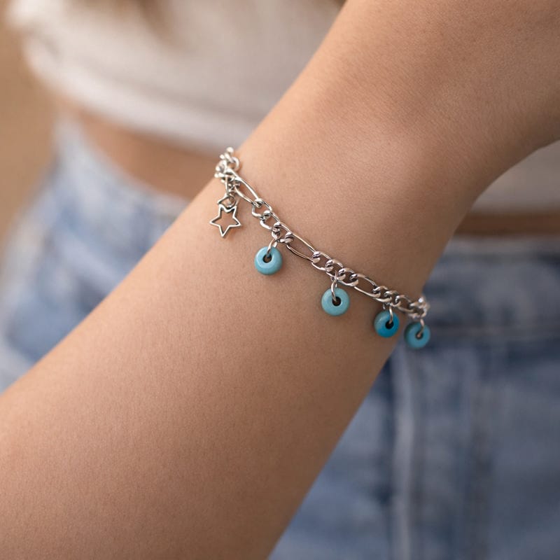 أسوارة فضية بخرز فيروزي ونجمة مفرغة على معصم امرأة ترتدي جينز