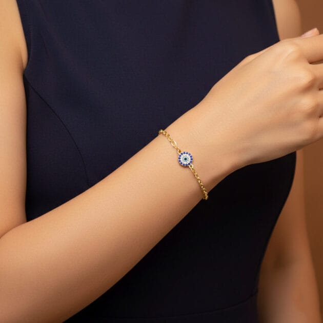 أسوارة ذهبية بقلادة عين زرقاء مرصعة على معصم امرأة