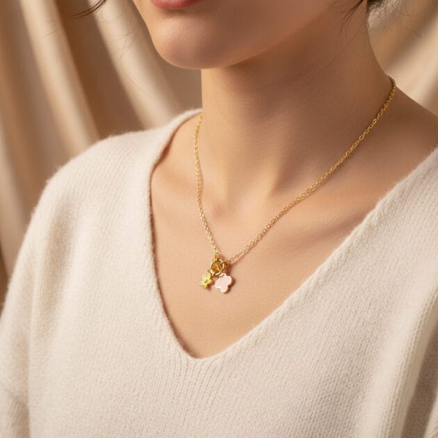 طوق ذهبي بقلادات زهرة وصفراء وبرسيم وردي على رقبة امرأة