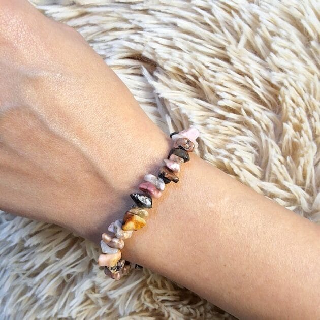 أسوارة أحجار طبيعية ملونة بأشكال غير منتظمة على معصم امرأة
