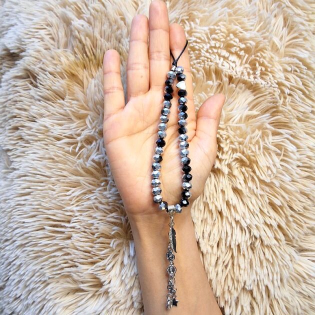 حمالة موبايل خرز كريستال أسود وفضي بقلادة ريشة ناعمة