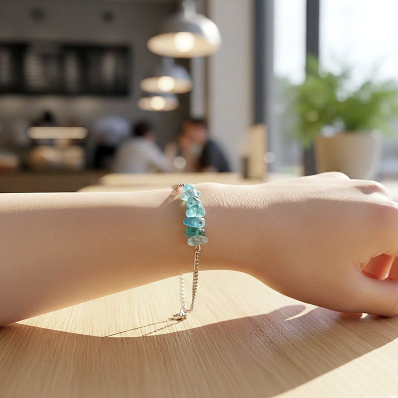 أسوارة فضية بأحجار أباتيت زرقاء مكسرة على معصم امرأة