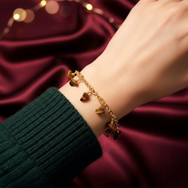 أسوارة ذهبية بقلادات أحجار عين النمر على معصم امرأة