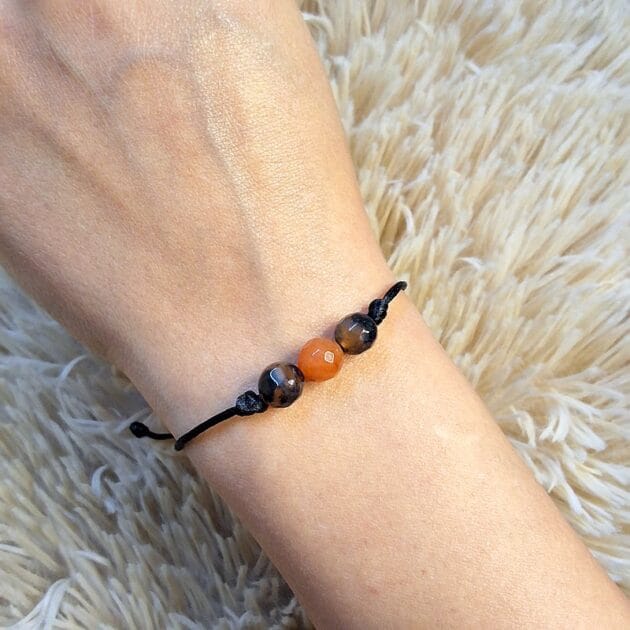 أسوارة خيط بحجر طبيعي بني وقرميدي بتصميم بسيط.