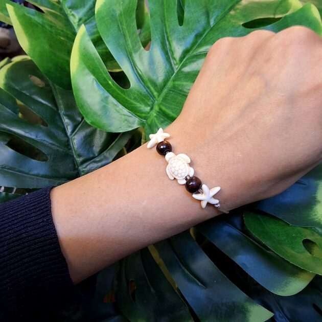 أسوارة خيط بتعليقة سلحفاة بيضاء.