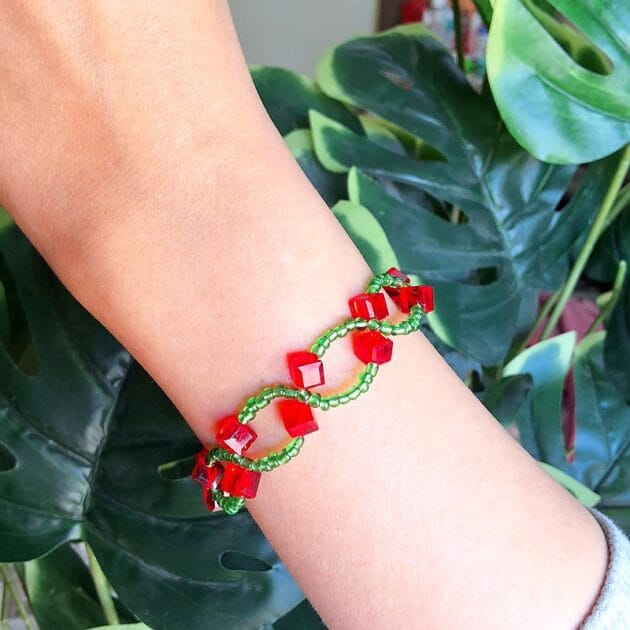 أسوارة خرز ملونة بالأحمر والأخضر مع مكعبات لامعة.