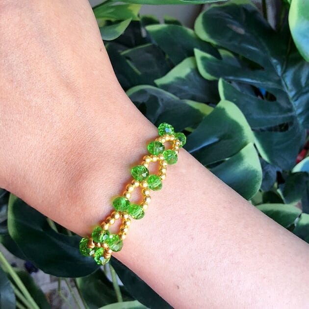 أسوارة كريستال أخضر مع تفاصيل ذهبية.