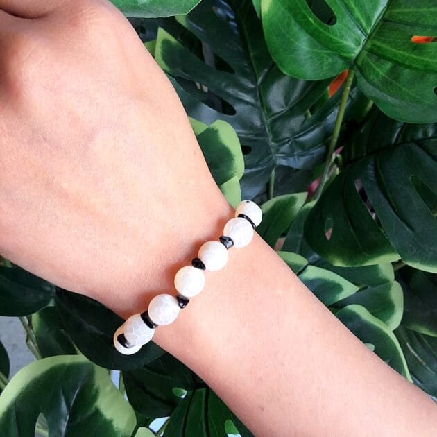 أسوارة خرز أبيض مع فواصل سوداء.