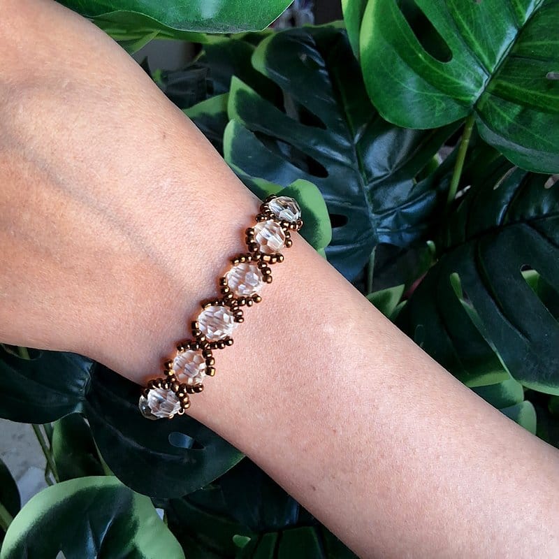 أسوارة خرز كريستال شفاف مع بني بتصميم بسيط.