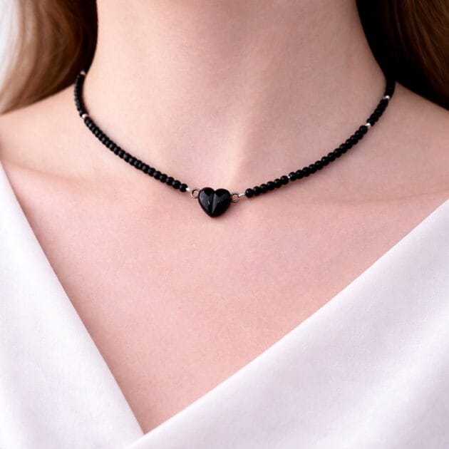 طوق خرز أسود بتعليقة قلب مغناطيسي.